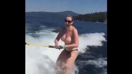 Girl roule sur le ski nautique seins nus