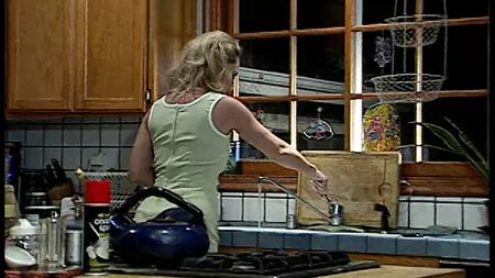 Une jeune et jolie blonde s'est fait séduire par une lesbienne plus âgée dans la cuisine
