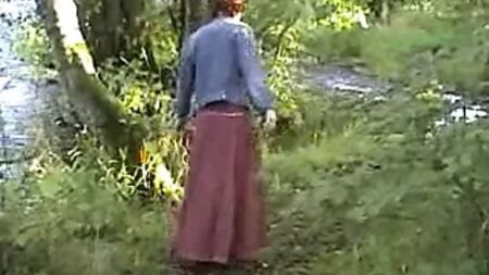 Une femme mûre et exhibitionniste se caresse au bord de la rivière