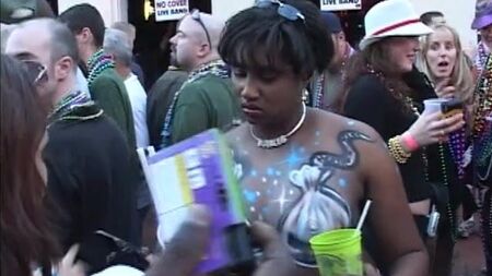 Des filles montrent leurs seins en échange de perles pendant le Mardi Gras