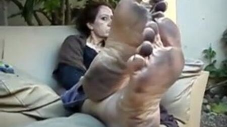 Une femme d'un certain âge montrant ses pieds sales