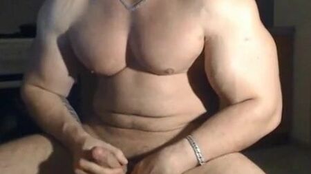 Un très bel homme musclé qui prend la pose et se masturbe