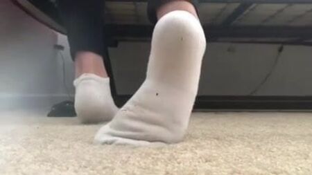 Une jeune fille de 18 ans en train d'enlever ses chaussettes