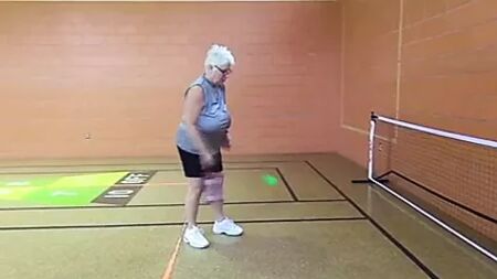 Une femme mûre aux gros seins tombants, sans soutien-gorge, joue au pickleball
