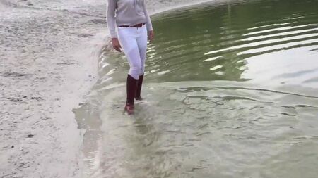 Je me promène dans le lac, les pieds trempés dans mes bottes d'équitation marron