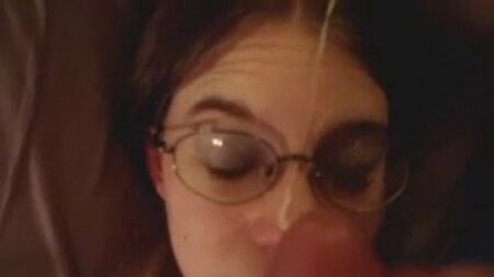 Une brune un peu intello à lunettes se fait gicler une grosse éjaculation faciale, en POV