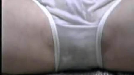 Une mignonne qui rit en culotte de nylon blanche