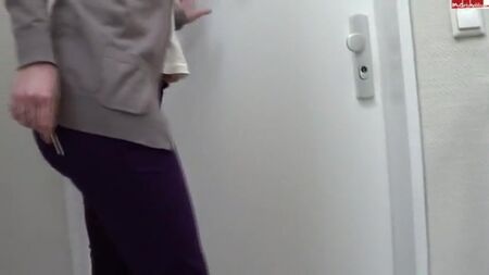 UNE FEMME FAIT PIPI DANS SON PANTALON VIOLET DEVANT SA MAISON