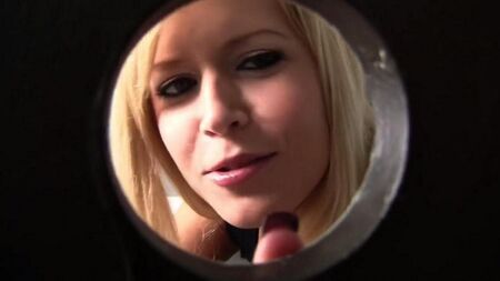 La blonde suce un membre à travers un trou dans les toilettes