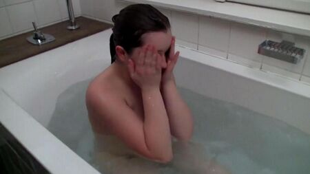 La dame se masturbe un tuyau d'une douche dans un bain
