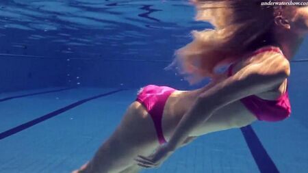 La beauté nue nage dans la piscine