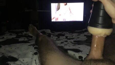 Il se masturbe devant un film porno avec un masturbateur