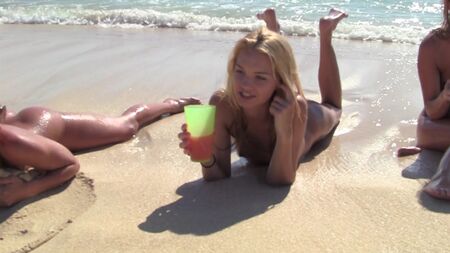 Des filles nues s'éclatent sur la plage